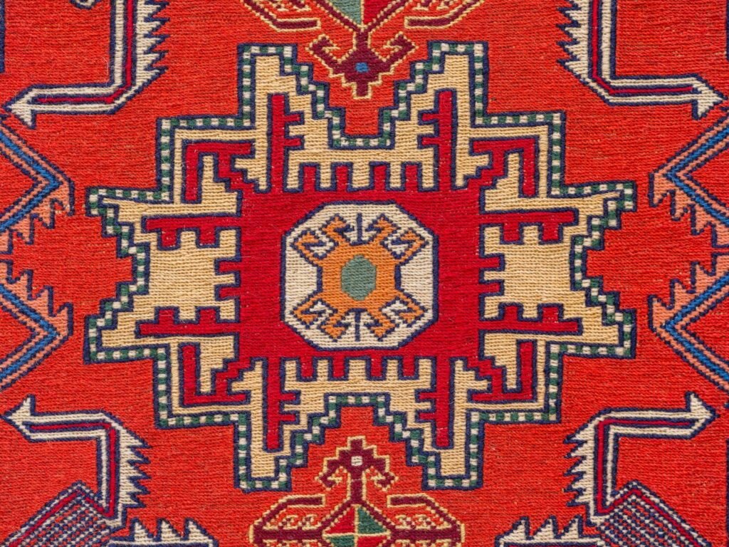 A red rug with an intricate design on it