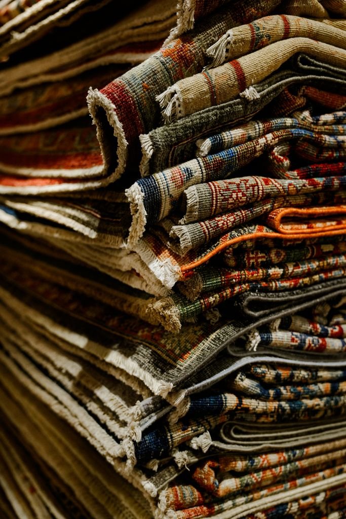 A close-up view of a stack of oriental rugs showcasing vivid patterns and rich textures.